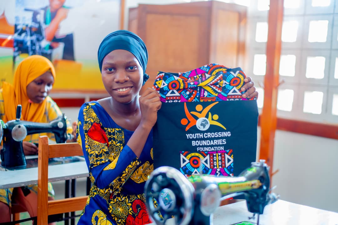 A Tansanian girl showing a bag she has sewn